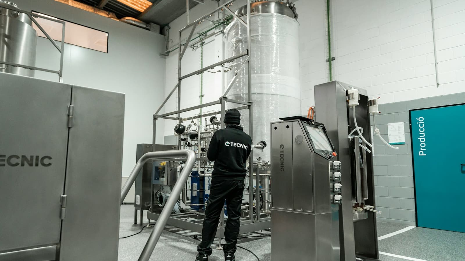 Monteur controleert een industriële installatie met leidingen en bedieningspanelen