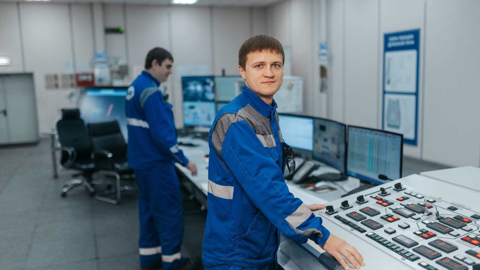 Technische medewerkers houden toezicht op een installatie vanuit een controlekamer