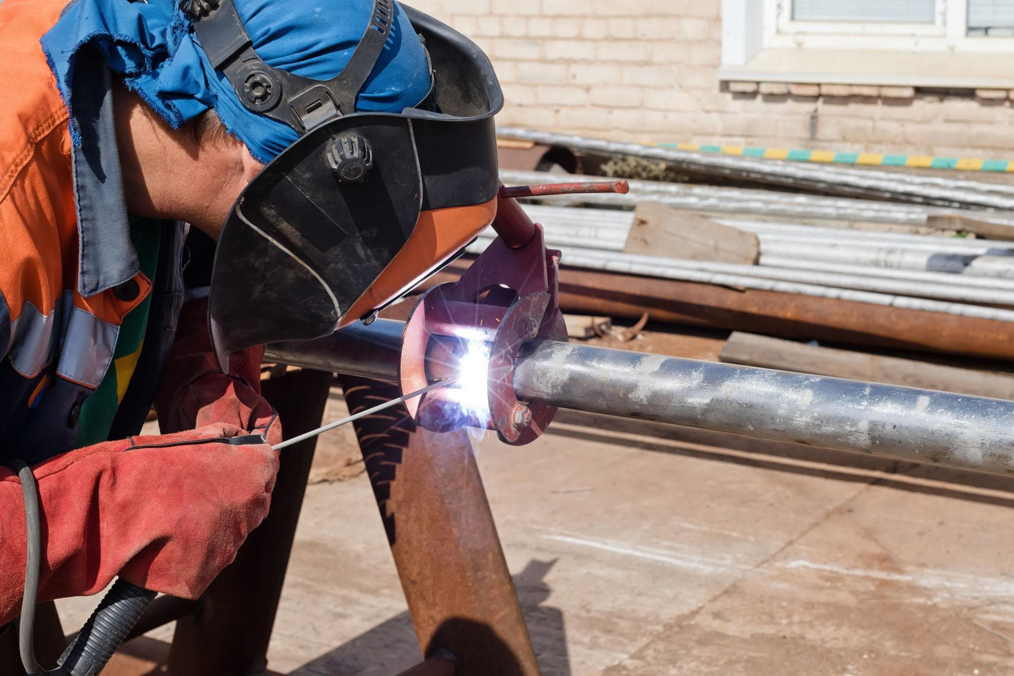 Lasser met laskap aan het werk aan een metalen constructie